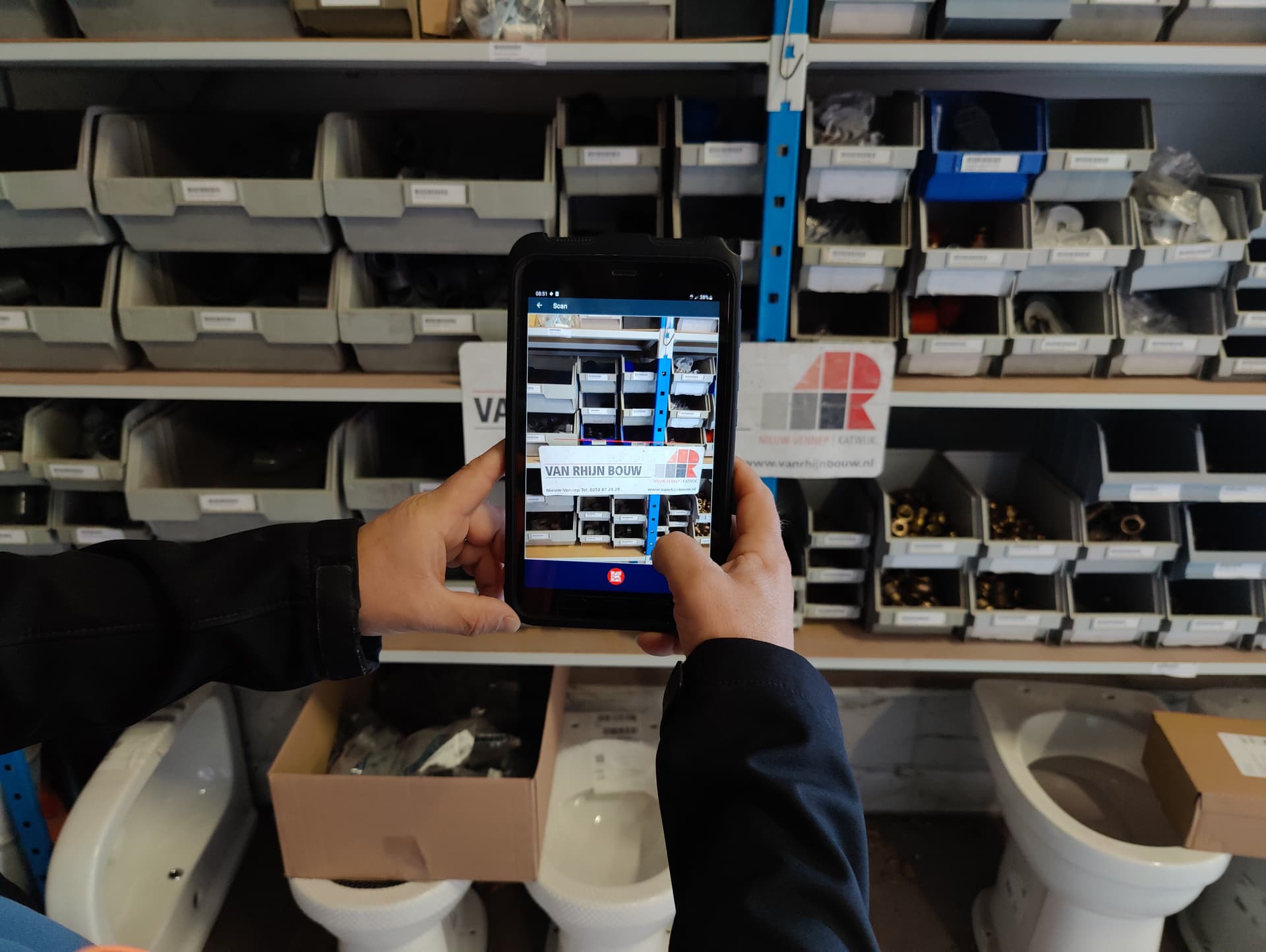 Medewerker van Van Rhijn Bouw scant materialen in het magazijn met de ScanWerkApp